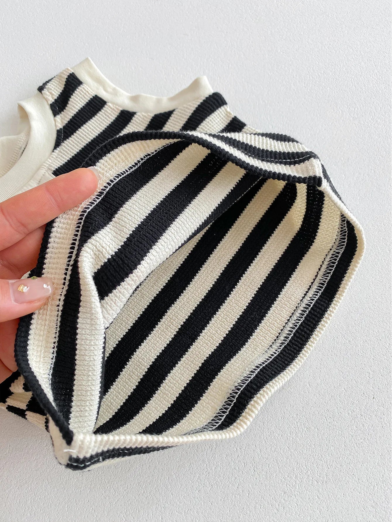Close-up of the interior of a striped sleeveless tee with black and white patterns, showcasing its fabric texture.